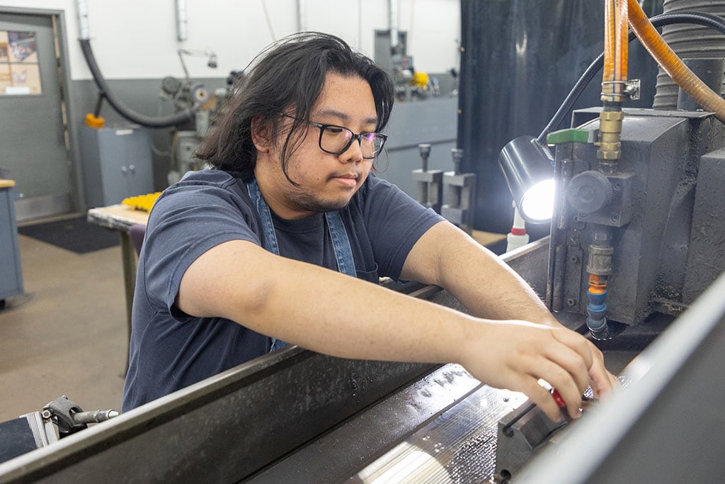 Ntm Employees Working On Machine Components