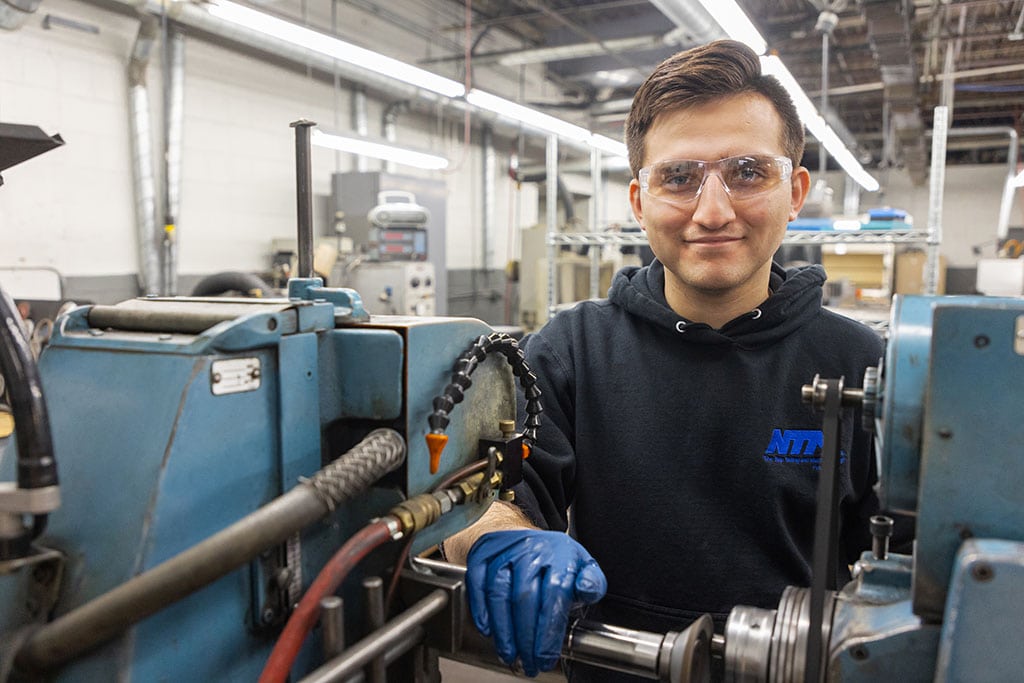Ntm Employee Working On Machine Components